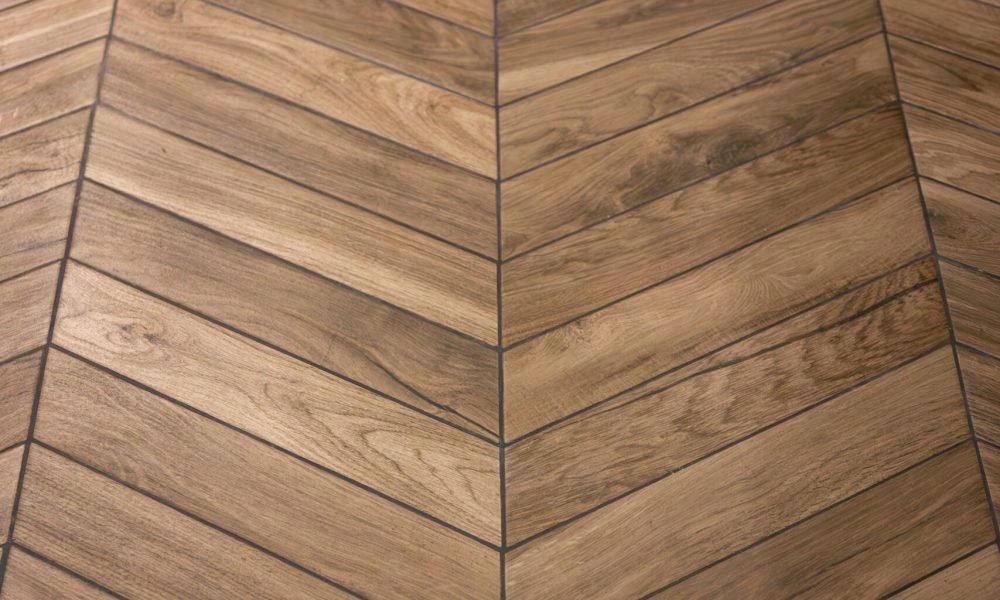 Stairs with wooden herringbone flooring. Warm parquet texture highlights a modern interior and the trend for natural materials.